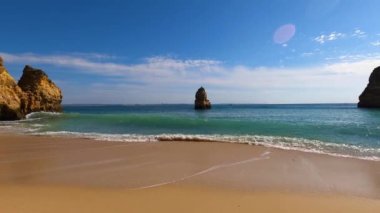 Kayalık uçurum kıyıları ve dalgaların üzerine çöktüğü cennet manzarası. Lagos 'taki Camillo plajı. Portekiz 'in güneyindeki Algarve bölgesinin Batı Atlantik kıyıları.