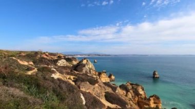Kayalık uçurum kıyıları ve dalgaların üzerine çöktüğü cennet manzarası. Lagos 'taki Camillo plajı. Portekiz 'in güneyindeki Algarve bölgesinin Batı Atlantik kıyıları.