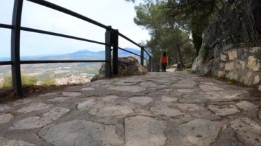 JAEN, SPAIN - 6 Nisan 2023: 6 Nisan 2023 'te İspanya' nın Jaen kentinde güneşli bir günde Santa Catalina 'nın ortaçağ şatosunun yanındaki taş yol