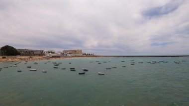 CADIZ, İspanya - 30 Nisan 2023: Cadiz, İspanya 'da La Caleta sahilinde tekneler