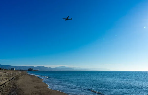 stock image MALAGA, SPAIN - MARCH 25, 2023: Airplane landing at sunrise over Mediterranean Sea, Costa del Sol in Malaga, Spain on March 25, 2023