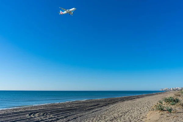 stock image MALAGA, SPAIN - MARCH 25, 2023: Airplane landing at sunrise over Mediterranean Sea, Costa del Sol in Malaga, Spain on March 25, 2023