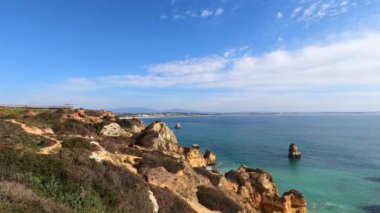 Kayalık uçurum kıyıları ve dalgaların üzerine çöktüğü cennet manzarası. Lagos 'taki Camillo plajı. Portekiz 'in güneyindeki Algarve bölgesinin Batı Atlantik kıyıları.