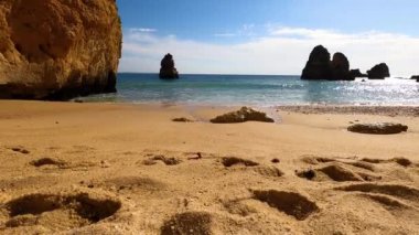 Kayalık uçurum kıyıları ve dalgaların üzerine çöktüğü cennet manzarası. Lagos 'taki Camillo plajı. Portekiz 'in güneyindeki Algarve bölgesinin Batı Atlantik kıyıları.
