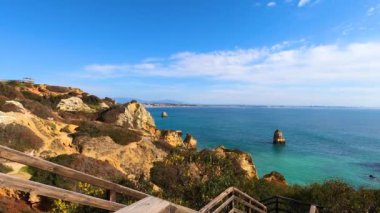 Kayalık uçurum kıyıları ve dalgaların üzerine çöktüğü cennet manzarası. Lagos 'taki Camillo plajı. Portekiz 'in güneyindeki Algarve bölgesinin Batı Atlantik kıyıları.