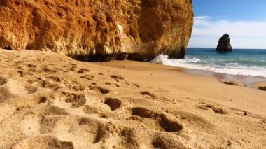 Kayalık uçurum kıyıları ve dalgaların üzerine çöktüğü cennet manzarası. Lagos 'taki Camillo plajı. Portekiz 'in güneyindeki Algarve bölgesinin Batı Atlantik kıyıları.