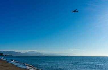 MALAGA, İspanya - 25 Mart 2023: Akdeniz üzerinde gün doğumunda iniş yapan uçak, Costa del Sol, Malaga, İspanya 25 Mart 2023