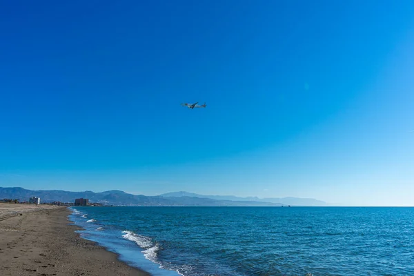 stock image MALAGA, SPAIN - MARCH 25, 2023: Airplane landing at sunrise over Mediterranean Sea, Costa del Sol in Malaga, Spain on March 25, 2023