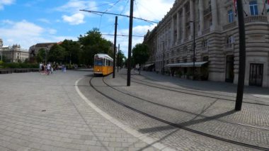 BUDAPEST, HUNGARY - 7 Temmuz 2023: Gündüz Macaristan Parlamentosu yakınlarında sarı tramvay. Budapeşte, Macaristan 'da 7 Temmuz 2023