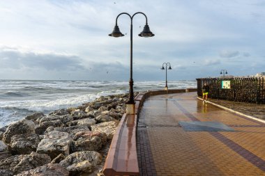 MALAGA, SPAIN - FEBRUARY 10, 2023: People walking on promenade during sea storm in Torremolinos, Malaga, Spain on February 10, 2023