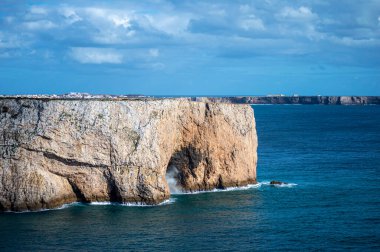 Kayalık uçurum kıyıları ve dalgaların üzerine çöktüğü cennet manzarası. Sagres yakınlarındaki kayalar. Portekiz 'in güneyindeki Algarve bölgesinin Batı Atlantik kıyıları.