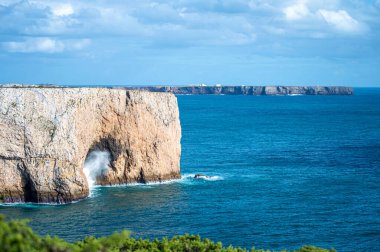 Kayalık uçurum kıyıları ve dalgaların üzerine çöktüğü cennet manzarası. Sagres yakınlarındaki kayalar. Portekiz 'in güneyindeki Algarve bölgesinin Batı Atlantik kıyıları.