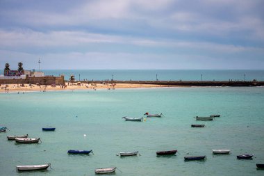 CADIZ, İspanya - 30 Nisan 2023: Cadiz, İspanya 'da La Caleta sahilinde tekneler