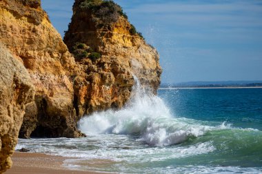 Kayalık uçurum kıyıları ve dalgaların üzerine çöktüğü cennet manzarası. Lagos 'taki Camillo plajı. Portekiz 'in güneyindeki Algarve bölgesinin Batı Atlantik kıyıları.