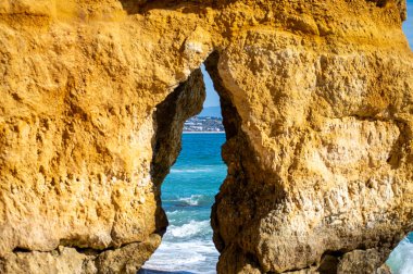 Kayalık uçurum kıyıları ve dalgaların üzerine çöktüğü cennet manzarası. Lagos 'taki Camillo plajı. Portekiz 'in güneyindeki Algarve bölgesinin Batı Atlantik kıyıları.