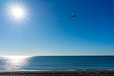 MALAGA, İspanya - 25 Mart 2023: Akdeniz üzerinde gün doğumunda iniş yapan uçak, Costa del Sol, Malaga, İspanya 25 Mart 2023