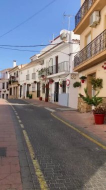 ESTEPONA, İspanya - 29 Temmuz 2023 'te İspanya' nın Estepona kentinde güneşli bir yaz gününde şehir merkezinde yürüyüş