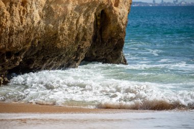 Kayalık uçurum kıyıları ve dalgaların üzerine çöktüğü cennet manzarası. Lagos 'taki Camillo plajı. Portekiz 'in güneyindeki Algarve bölgesinin Batı Atlantik kıyıları.