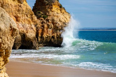 Kayalık uçurum kıyıları ve dalgaların üzerine çöktüğü cennet manzarası. Lagos 'taki Camillo plajı. Portekiz 'in güneyindeki Algarve bölgesinin Batı Atlantik kıyıları.