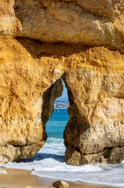 Kayalık uçurum kıyıları ve dalgaların üzerine çöktüğü cennet manzarası. Lagos 'taki Camillo plajı. Portekiz 'in güneyindeki Algarve bölgesinin Batı Atlantik kıyıları.