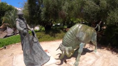 ESTEPONA, İspanya - 29 Temmuz 2023: Estepona, İspanya 'da boğa güreşi ringi önünde Toreador ve boğa heykeli