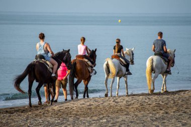 MALAGA, İspanya - 23 Haziran 2023: Malaga, İspanya 'da gün batımında deniz kıyısında sürücüler