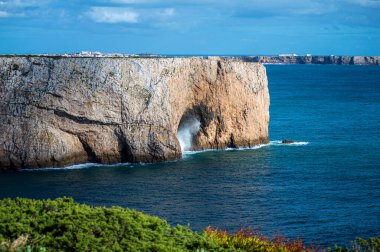 Kayalık uçurum kıyıları ve dalgaların üzerine çöktüğü cennet manzarası. Sagres yakınlarındaki kayalar. Portekiz 'in güneyindeki Algarve bölgesinin Batı Atlantik kıyıları.
