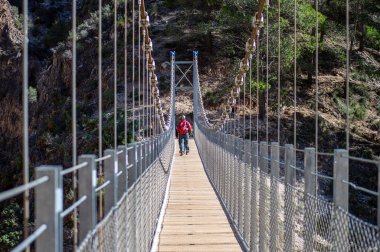 CANILLAS DE ACEITUNO, İspanya - 2 Mart 2024: Colgante köprüsüne (Puente Colgante El Saltillo) yürüyüş yolu Canillas de Aceituno, İspanya 2 Mart 2024