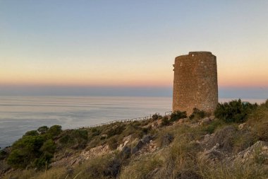 Akdeniz üzerinde gün batımı. Tarihsel Torre Vigia De Cerro Gordo. Yağmacı korsanlara dikkat eden bir gözetleme kulesi. La Herradura, Andulasia, Güney İspanya
