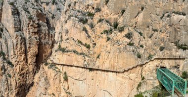 EL CHORRO, İspanya - 19 Mart 2024: Caminito del Rey, Kralın Yolu. 19 Mart 2024 'te Malaga, İspanya' nın El Chorro kentindeki dar bir geçitin sarp duvarları boyunca sıkıştı.