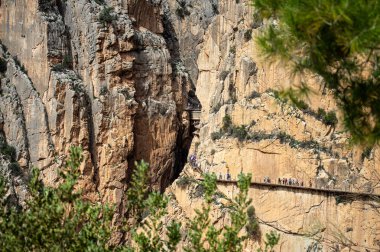 EL CHORRO, İspanya - 19 Mart 2024: Caminito del Rey, Kralın Yolu. 19 Mart 2024 'te Malaga, İspanya' nın El Chorro kentindeki dar bir geçitin sarp duvarları boyunca sıkıştı.