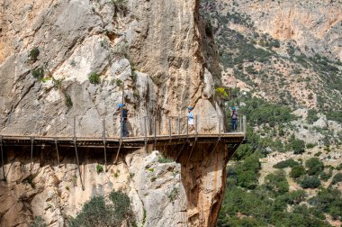 EL CHORRO, İspanya - 19 Mart 2024: Caminito del Rey, Kralın Yolu. 19 Mart 2024 'te Malaga, İspanya' nın El Chorro kentindeki dar bir geçitin sarp duvarları boyunca sıkıştı.