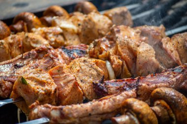 Metal şiş üzerinde ızgara domuz eti ve mantar. Shashlik ya da şiş kebap ızgarada ızgara kömürle ızgara sebzeyle hazırlandı..
