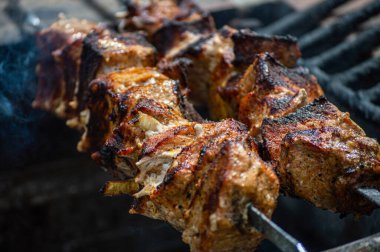 Metal şiş üzerinde ızgara domuz eti. Shashlik ya da şiş kebap ızgarada ızgara kömürle ızgara sebzeyle hazırlandı..