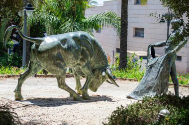 ESTEPONA, İspanya - 29 Temmuz 2023: Estepona, İspanya 'da boğa güreşi ringi önünde Toreador ve boğa heykeli