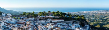 MIJAS, SPAIN - 7 Temmuz 2024: Kosta del Sol 'a tepeden bakan, İspanya' nın Endülüs kentindeki Mijas, Endülüs kentindeki beyaz yıkanmış binalar köyü ile tanınan büyüleyici beyaz İspanyol köyü