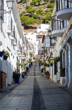 MIJAS, SPAIN - 7 Temmuz 2024: Kosta del Sol 'a tepeden bakan, İspanya' nın Endülüs kentindeki Mijas, Endülüs kentindeki beyaz yıkanmış binalar köyü ile tanınan büyüleyici beyaz İspanyol köyü