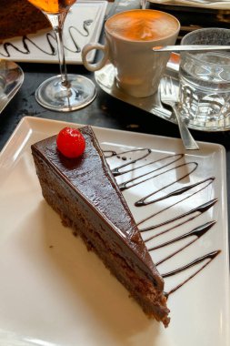 Avusturya, Viyana 'daki Cafe' de bir dilim Sacher Torte keki. Meşhur Avusturya çikolatalı sünger keki, yakın plan kayısı reçeli.