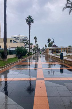 TORREMOLINOS, SPAIN - 14 Ekim 2024: 14 Ekim 2024 'te İspanya' nın Torremolinos kentinde yağmurlu ve bulutlu havada sabah yürüyüşü