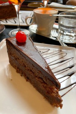 Avusturya, Viyana 'daki Cafe' de bir dilim Sacher Torte keki. Meşhur Avusturya çikolatalı sünger keki, yakın plan kayısı reçeli.