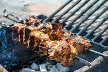 Metal şiş üzerinde ızgara domuz eti. Shashlik ya da şiş kebap ızgarada ızgara kömürle ızgara sebzeyle hazırlandı..