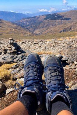 SIERRA NEVADA, SPAIN - 5 Ekim 2024: 5 Ekim 2024 tarihinde İspanya 'da Sierra Nevada Ulusal Parkı' ndaki Mulhacen Tepesi 'ne yürüyüş yolunda Jack Wolfskin' in botlarıyla insan bacakları görüntülendi