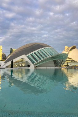 VALENCIA, İspanya - 18 Kasım 2024 'te İspanya' nın Valencia şehrinin sakin sularına yansıyan altın gündoğumu, gelecekteki mimariyi aydınlatır.