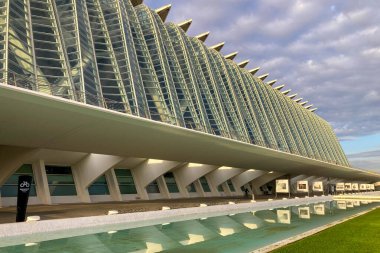 VALENCIA, İspanya - 18 Kasım 2024 'te İspanya' nın Valencia şehrinin sakin sularına yansıyan altın gündoğumu, gelecekteki mimariyi aydınlatır.