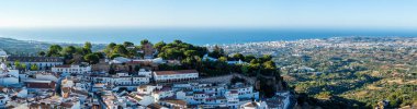 MIJAS, SPAIN - 7 Temmuz 2024: Kosta del Sol 'a tepeden bakan, İspanya' nın Endülüs kentindeki Mijas, Endülüs kentindeki beyaz yıkanmış binalar köyü ile tanınan büyüleyici beyaz İspanyol köyü