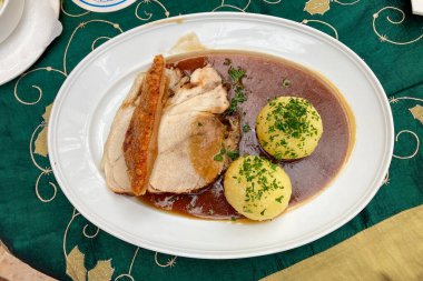 Traditional German food -  Schweinebraten (roast pork) served with potato dumplings clipart