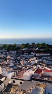 MIJAS, SPAIN - 7 Temmuz 2024: Kosta del Sol 'a tepeden bakan, İspanya' nın Endülüs kentindeki Mijas, Endülüs kentindeki beyaz yıkanmış binalar köyü ile tanınan büyüleyici beyaz İspanyol köyü