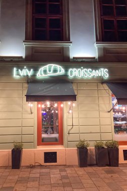 SLOVAKIA, BRATISLAVA - 8 Ocak 2025: Bratislava 'daki tarihi şehir merkezinde Lviv Croissants restoranının ışıkları