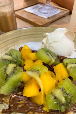 Çikolatalı kivi, mango, muz ve dondurmalı krema.