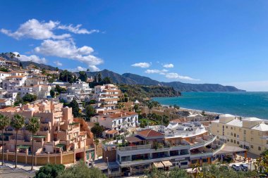NERJA, İspanya - 22 Mart 2025: Işıldayan deniz ve büyüleyici şehrin muhteşem manzaraları, 22 Mart 2025 tarihinde İspanya 'nın Nerja kentinde nefes kesen kıyı manzaraları ve pitoresk bir atmosfer sunuyor.